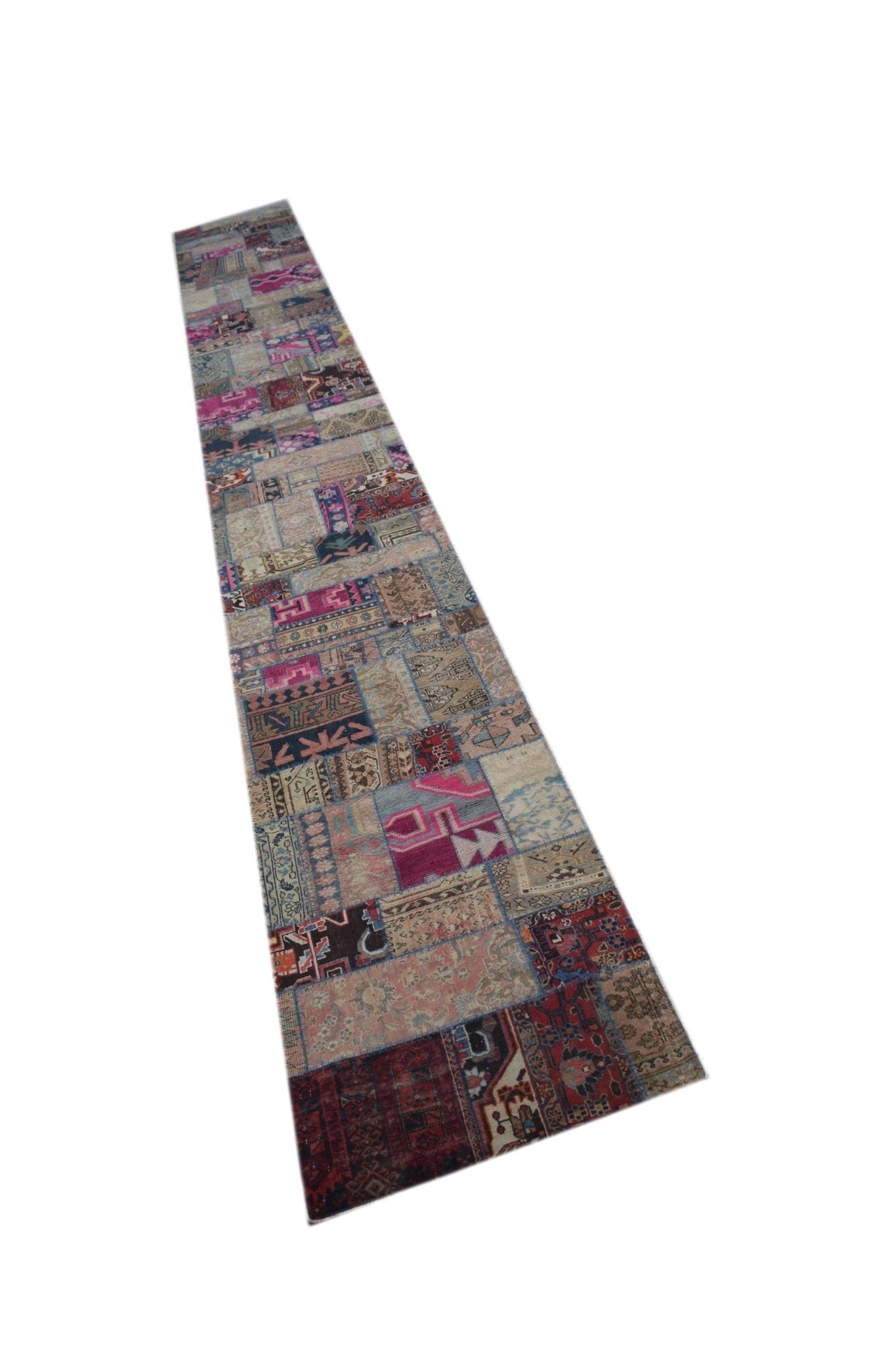 A long, handmade vintage patchwork runner rug featuring a variety of colorful wool patterns.