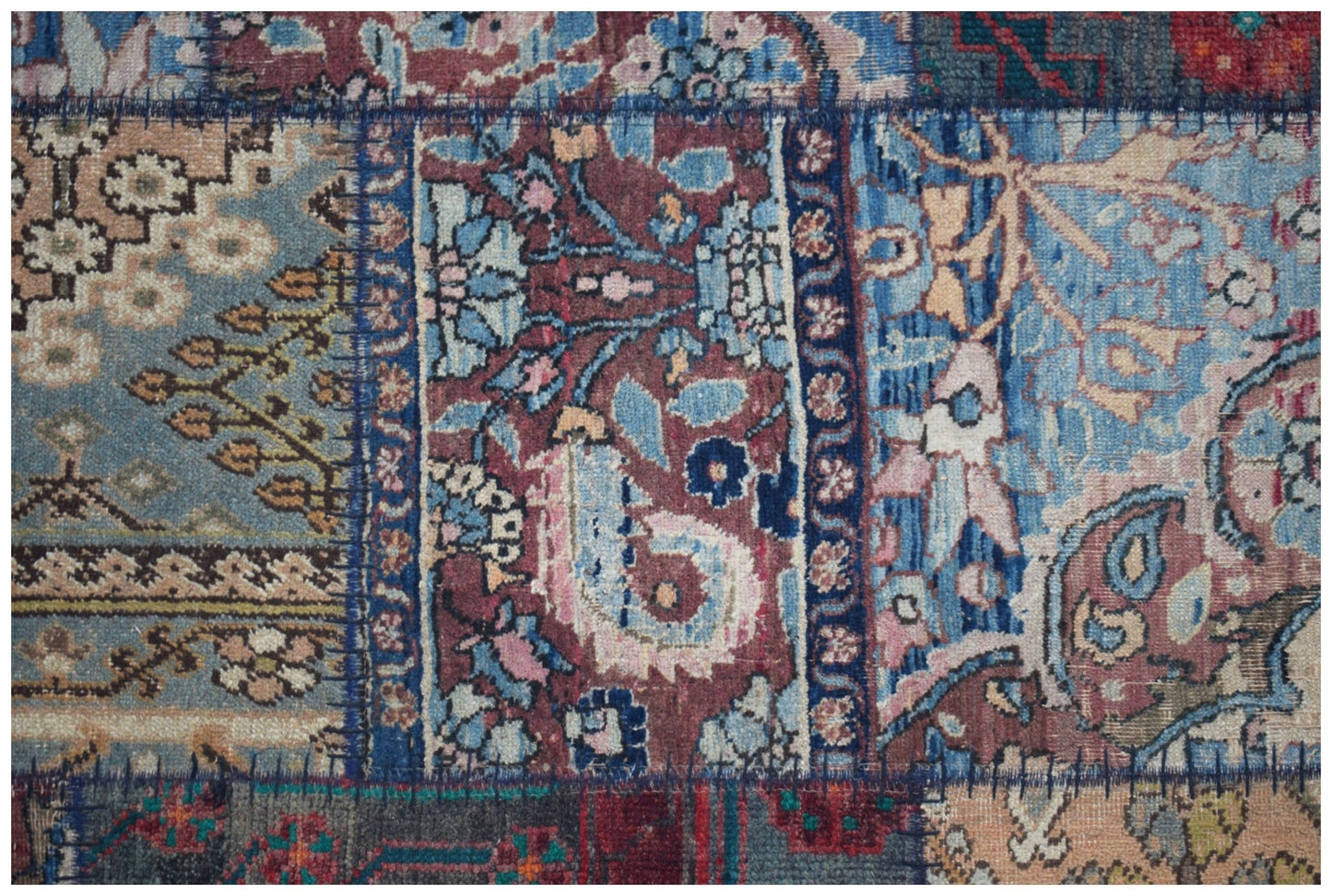 A vintage patchwork runner featuring a variety of intricate floral and paisley patterns in wool.