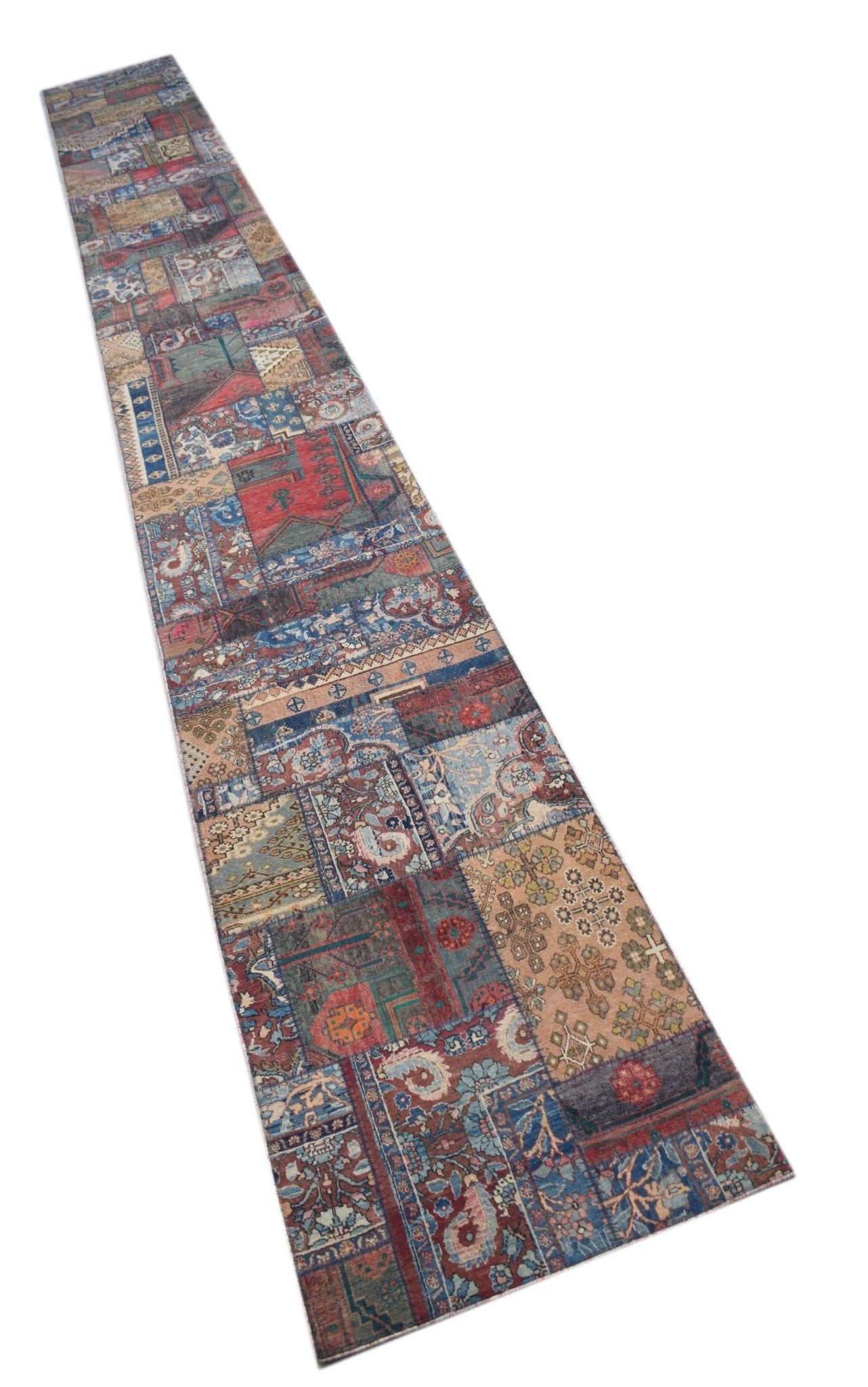 A long, handmade vintage patchwork runner rug featuring a variety of colorful, patterned wool tiles.