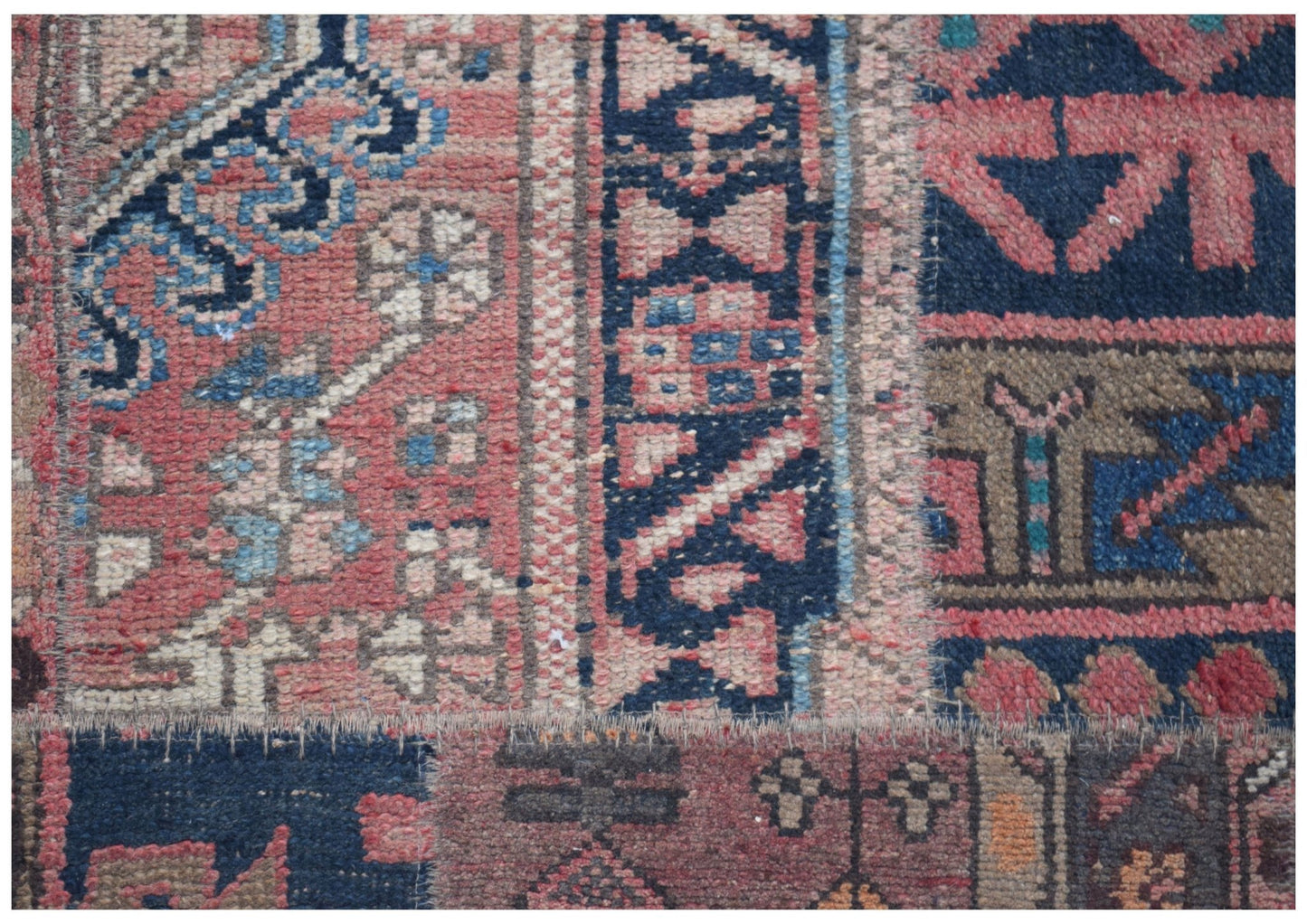 A close-up of a handmade vintage patchwork runner featuring intricate wool patterns in muted tones.