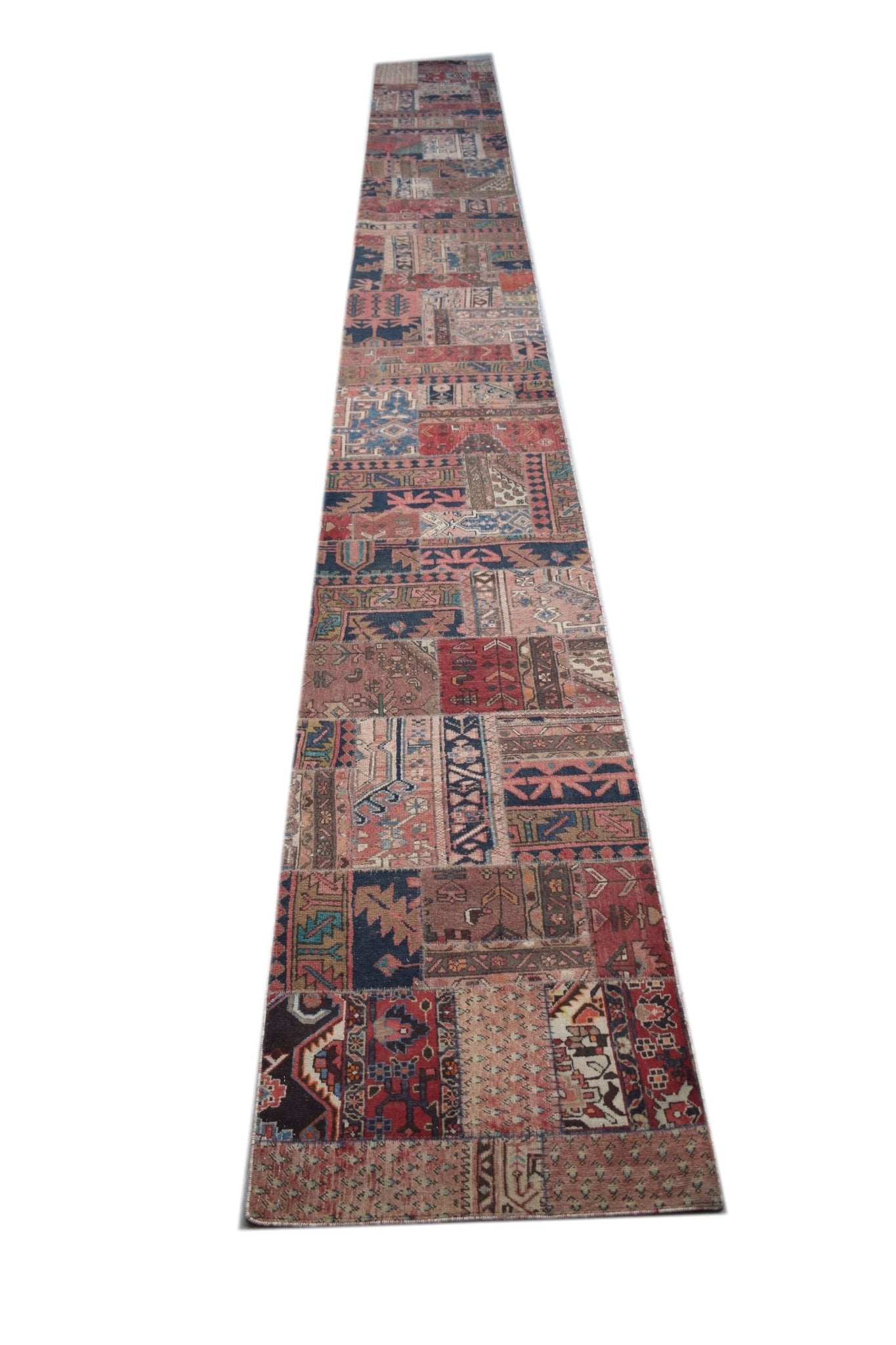 A long, handmade vintage patchwork runner rug featuring a variety of colorful, patterned wool tiles.