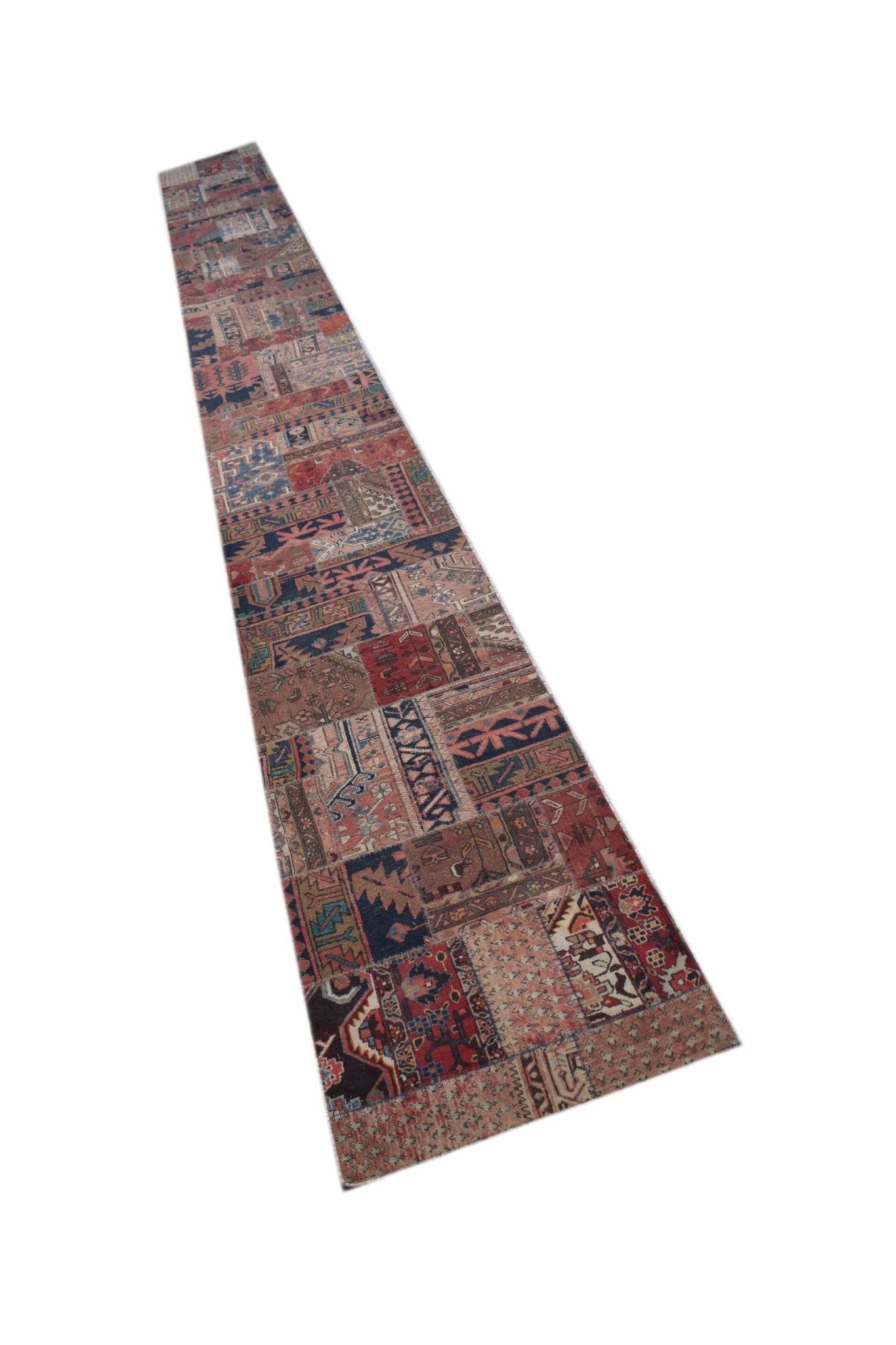 A long, narrow vintage runner rug featuring a colorful patchwork of various traditional patterns.