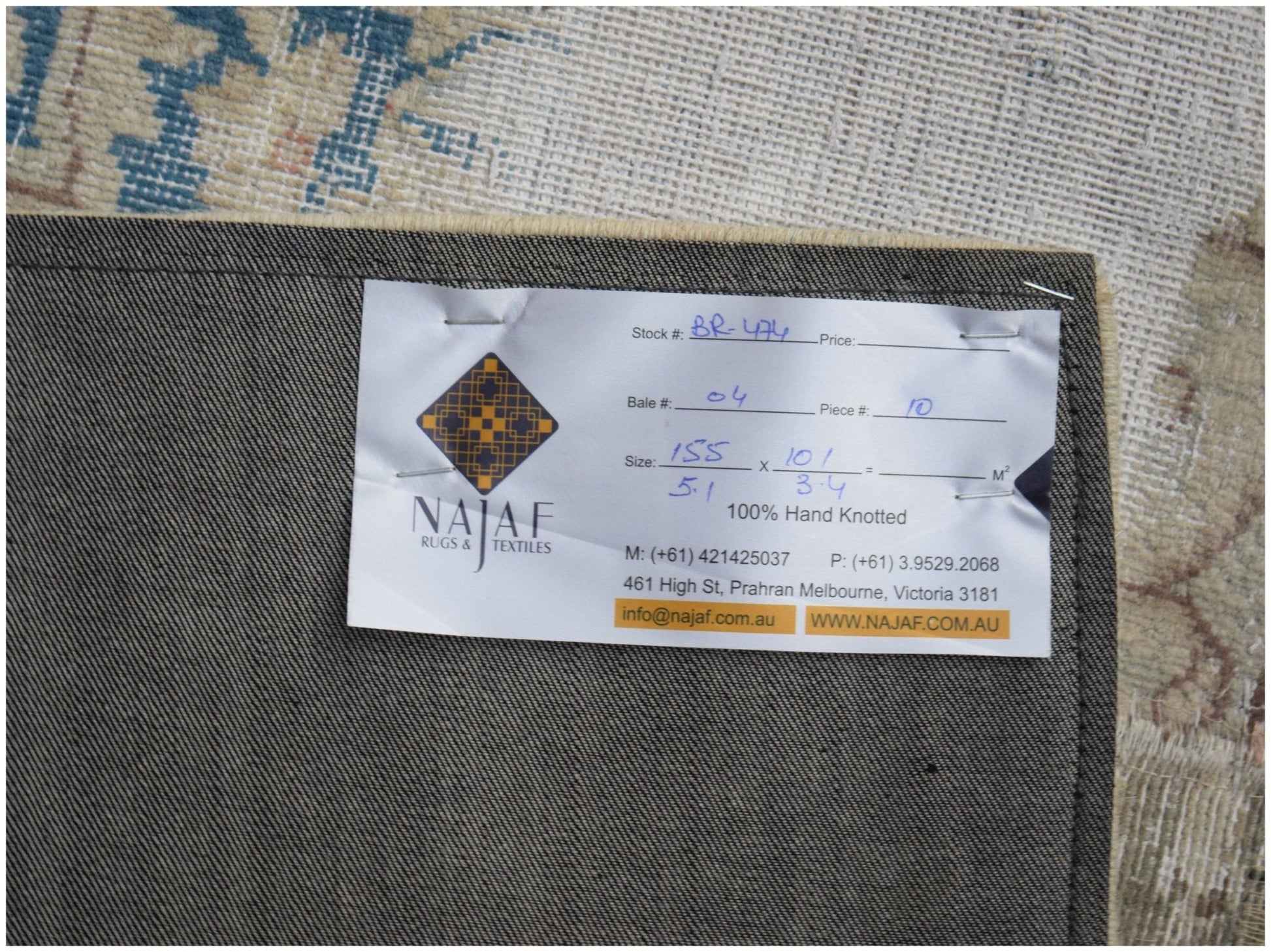 The underside of a handmade vintage patchwork rug showing a product label from Najaf Rugs.