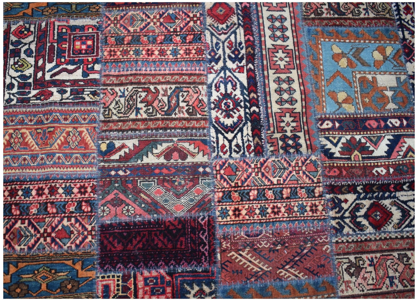 A handmade patchwork rug featuring a variety of vintage wool patterns in vibrant colors.