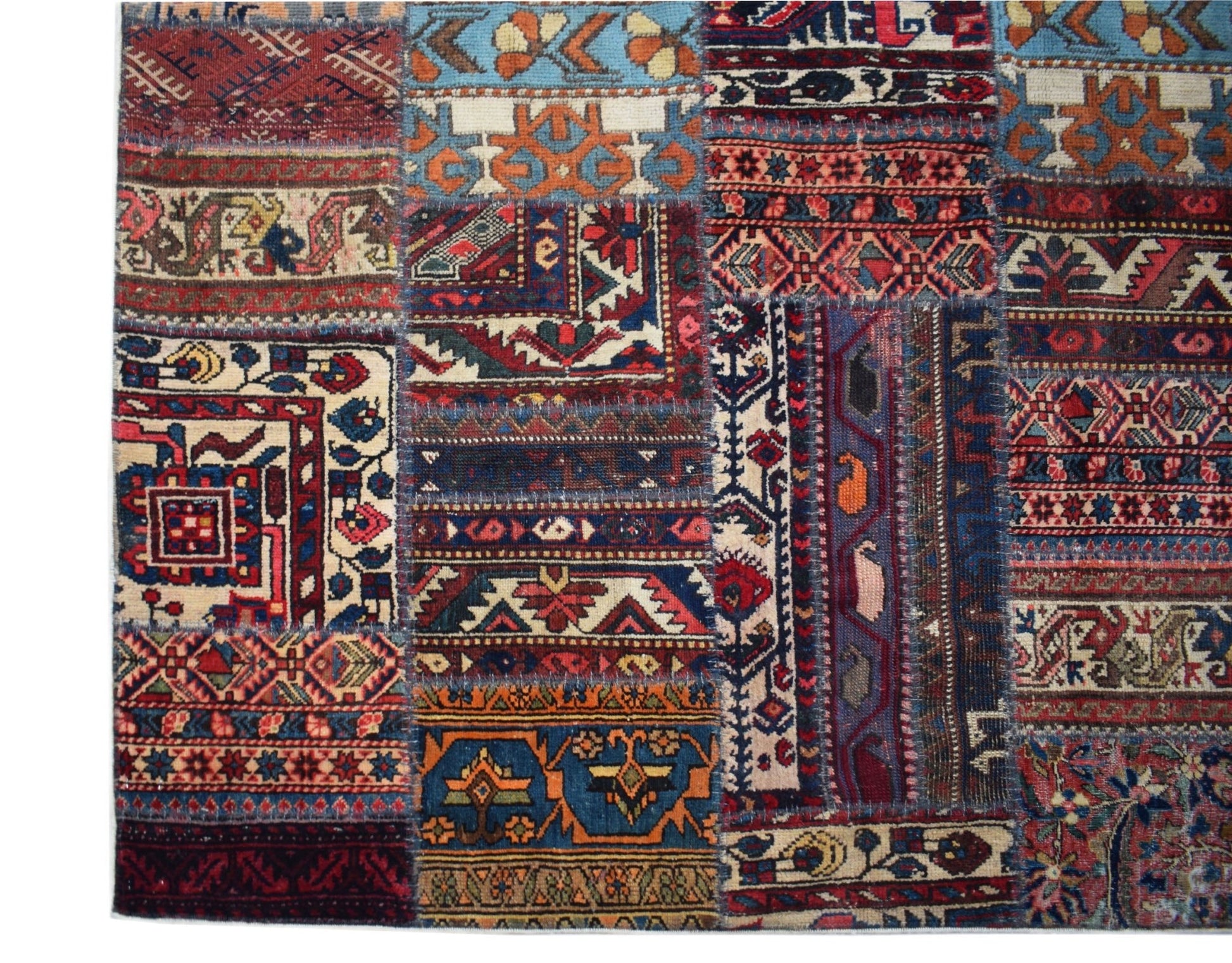 A handmade vintage patchwork rug featuring a colorful array of traditional Afghan wool patterns.