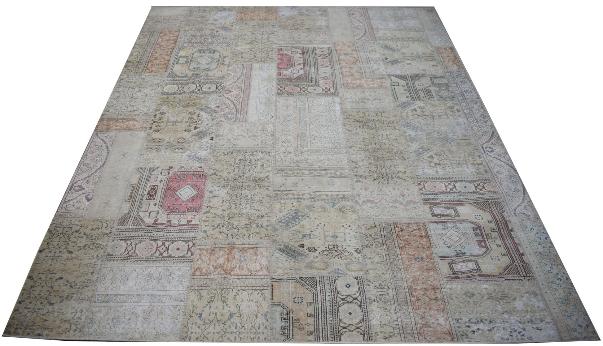 A handmade vintage patchwork rug featuring a neutral color palette with faded geometric patterns.