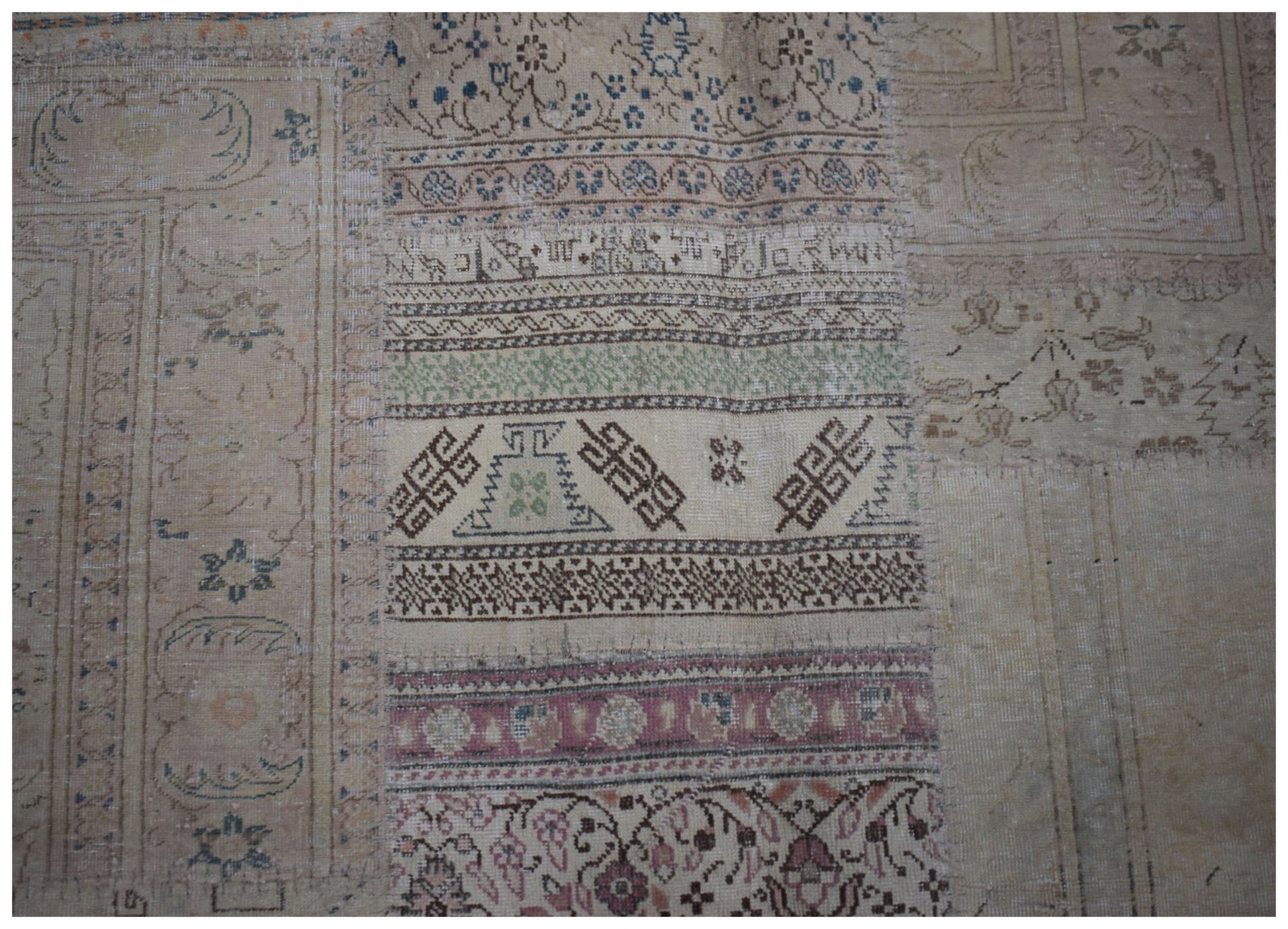 A handmade vintage patchwork rug featuring a variety of intricate geometric and floral patterns.
