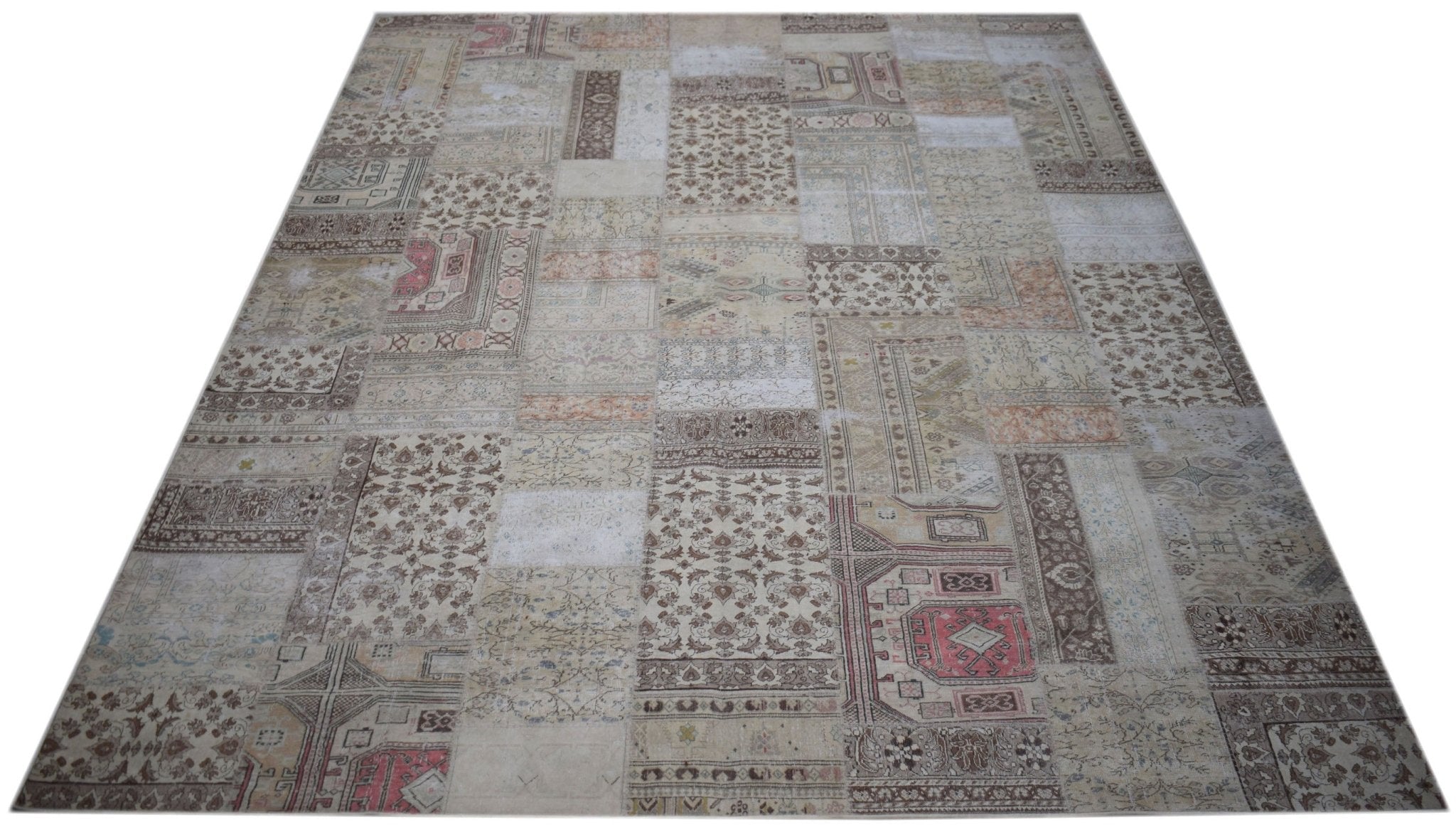 A handmade vintage patchwork rug featuring a neutral color palette with intricate floral patterns.