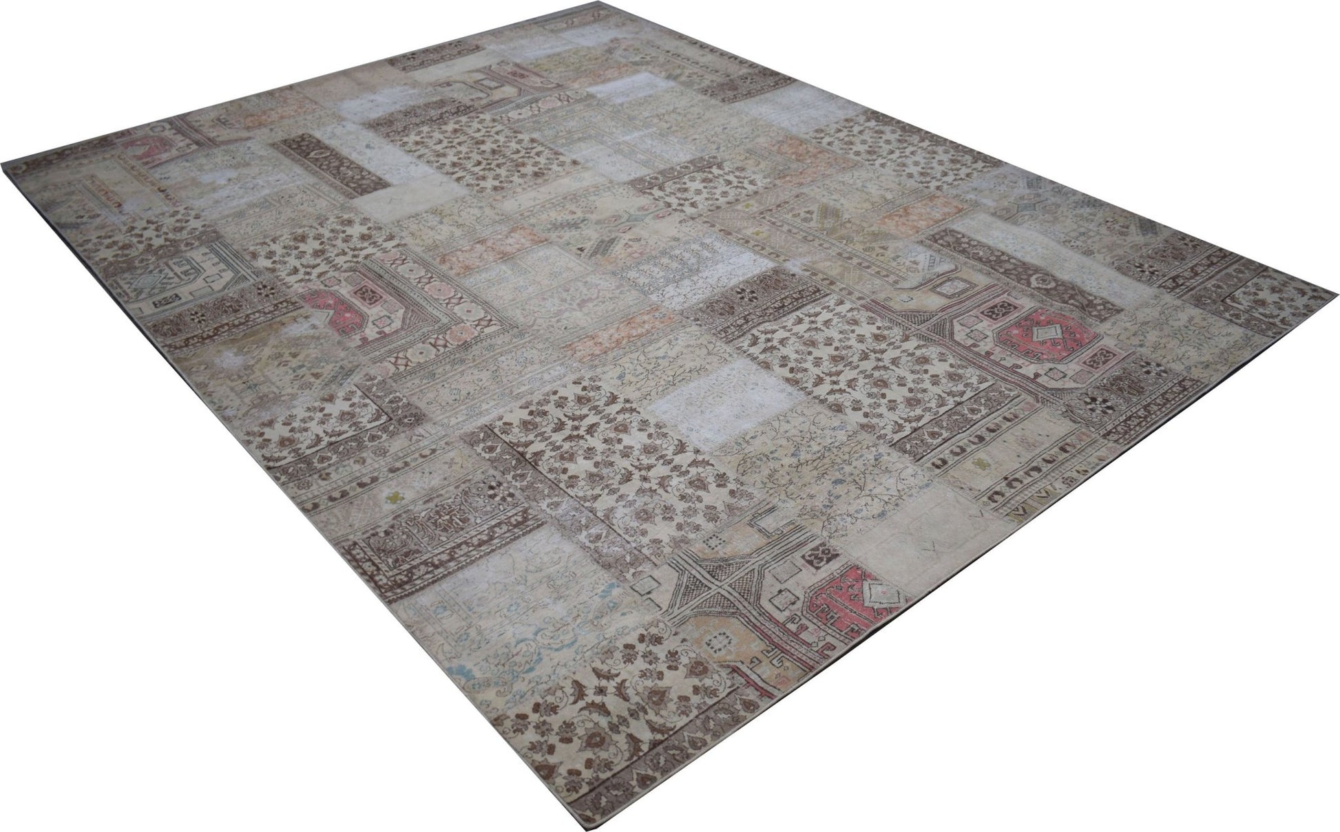 A handmade vintage patchwork rug featuring a neutral color palette with faded floral patterns.