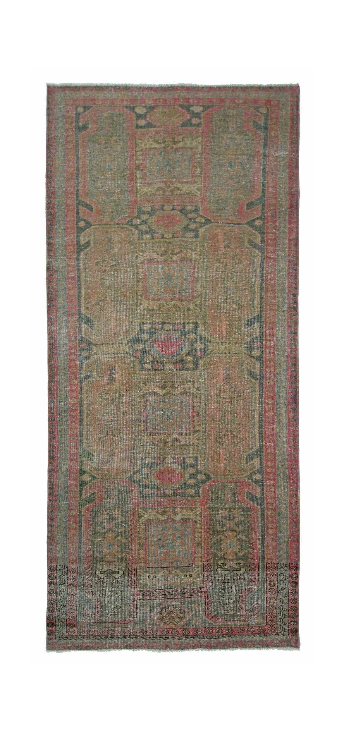 A vintage Persian Ardabil runner rug featuring geometric patterns in muted green and pink tones.