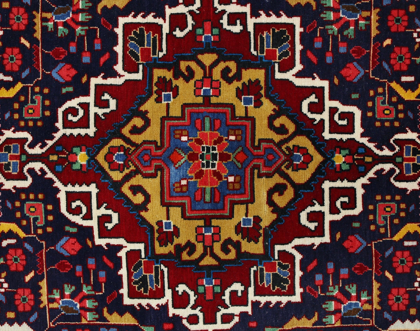 A vintage Persian Bakhtiari rug featuring a geometric central medallion in red, blue, and gold.