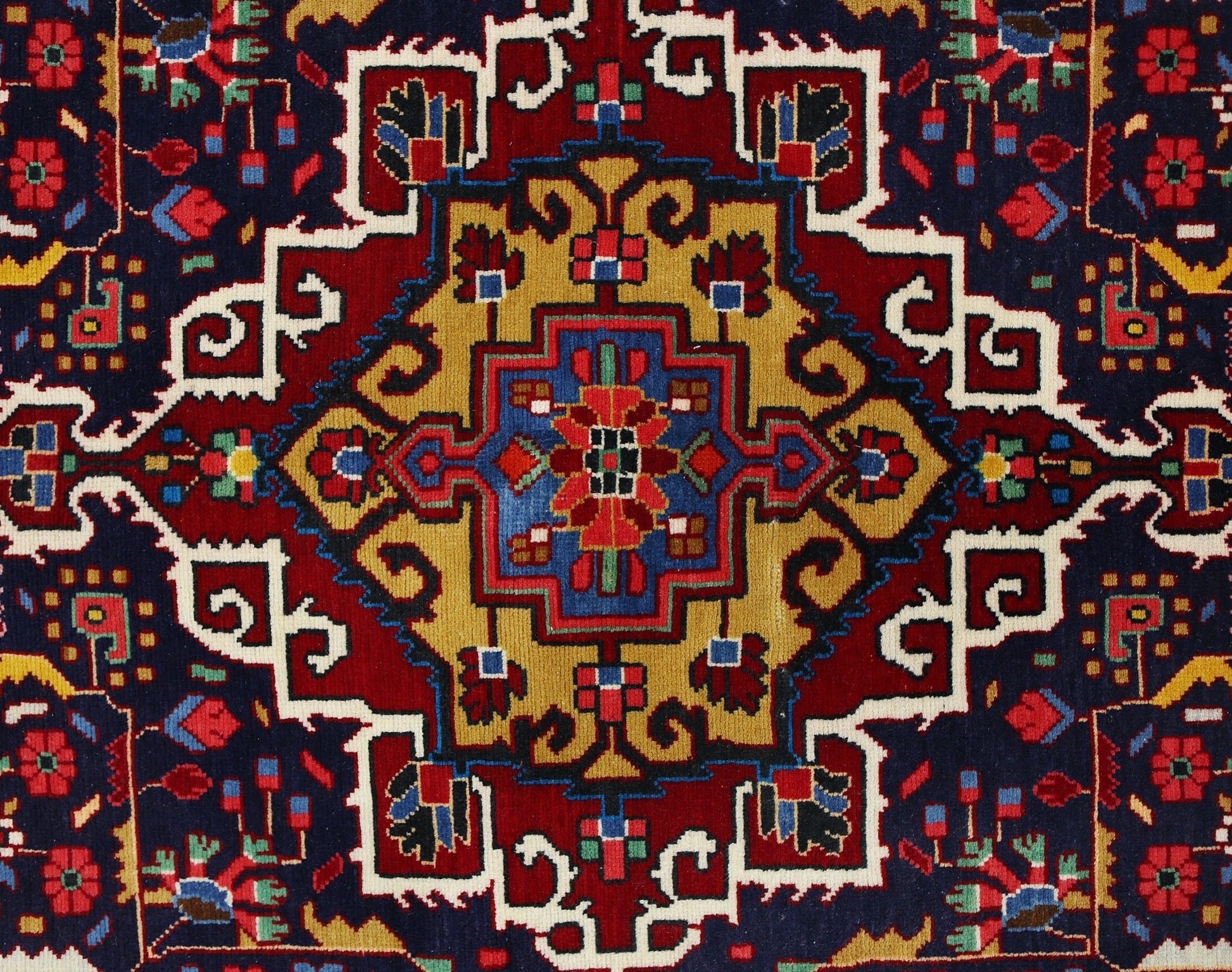 A vintage Persian Bakhtiari rug featuring a geometric central medallion in red, blue, and gold.