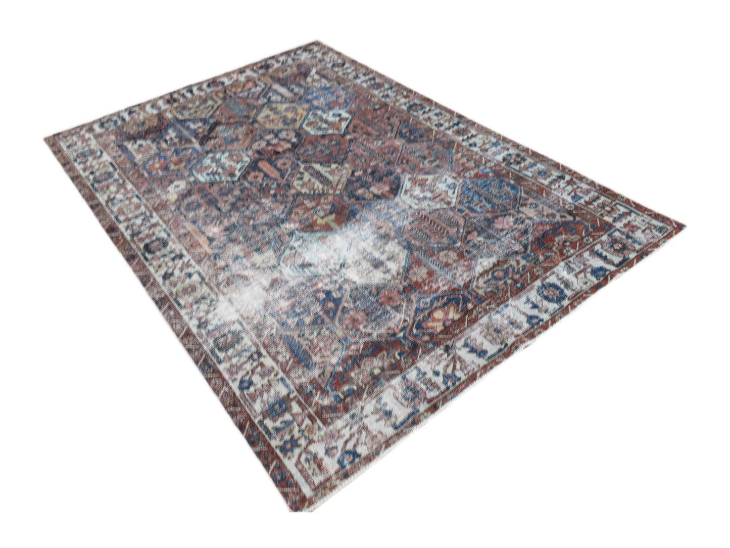 A vintage Persian Bakhtiari rug featuring a distressed, multi-colored geometric pattern.