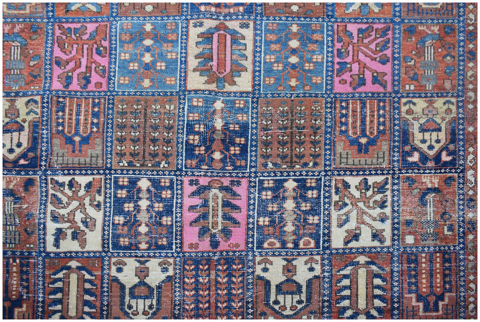 A vintage Persian Bakhtiari rug featuring a handwoven grid of colorful floral and geometric motifs.