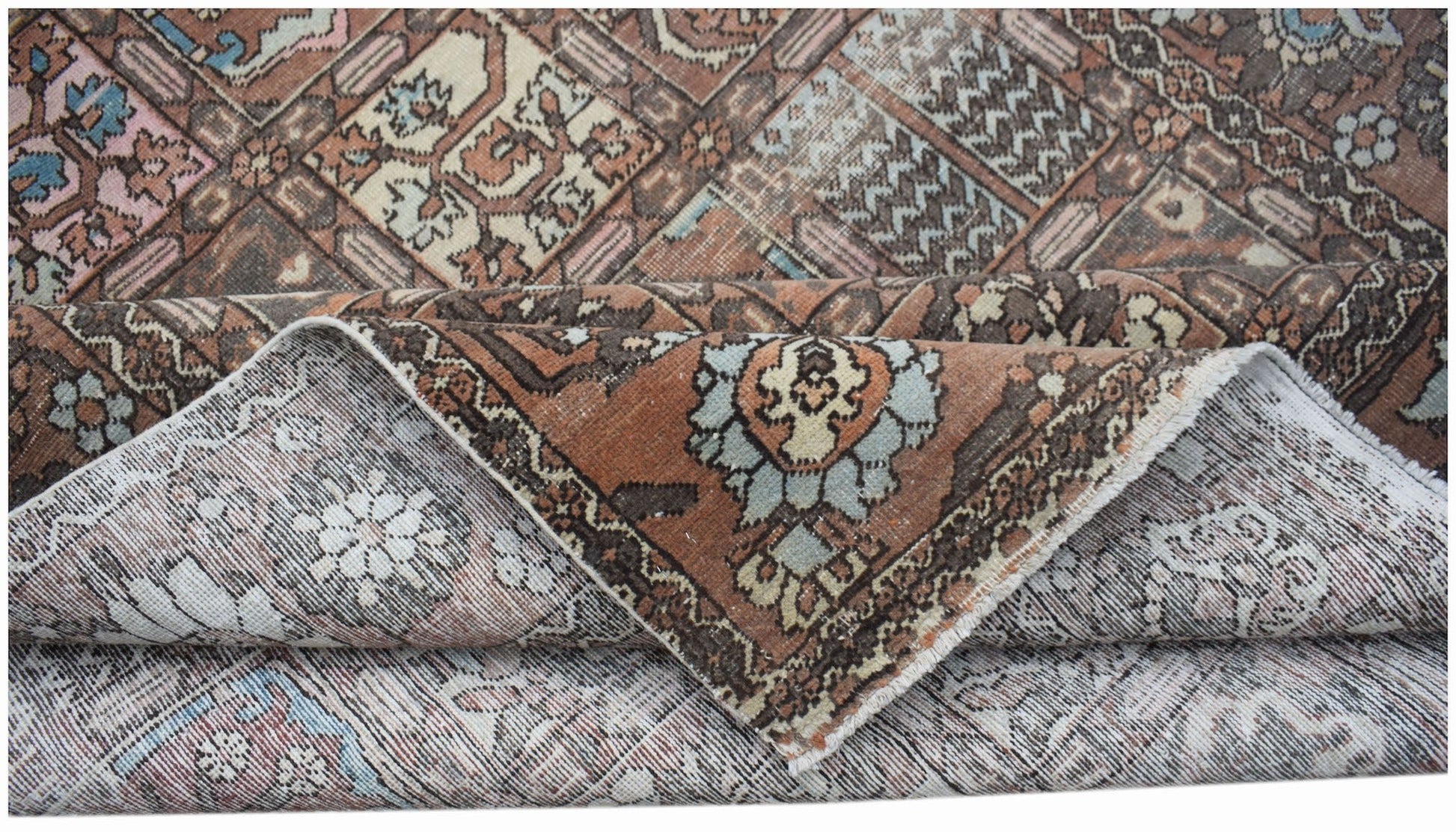 A vintage Persian Bakhtiari rug featuring a geometric pattern in muted brown, blue, and cream tones.