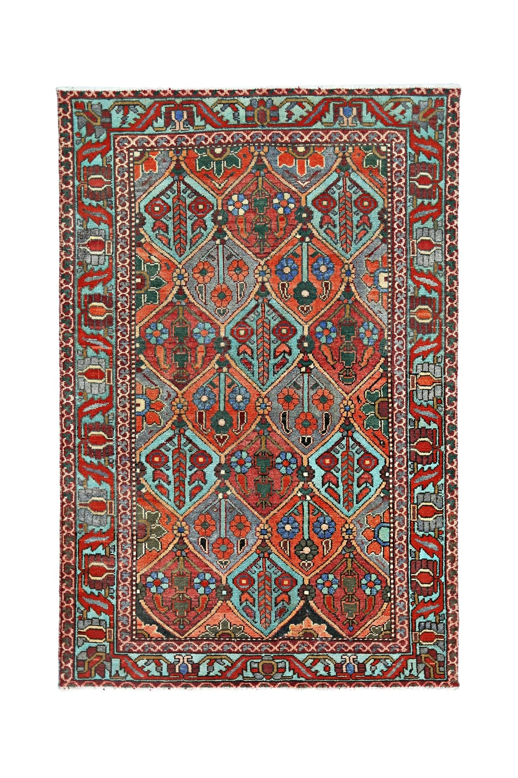 A vintage Persian Bakhtiari rug featuring a geometric diamond pattern in vibrant red and blue tones.
