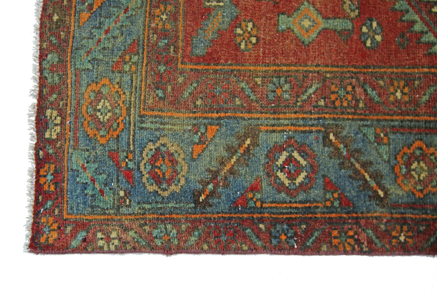 A vintage Persian Bibikabad rug featuring intricate geometric patterns in red, blue, and orange.