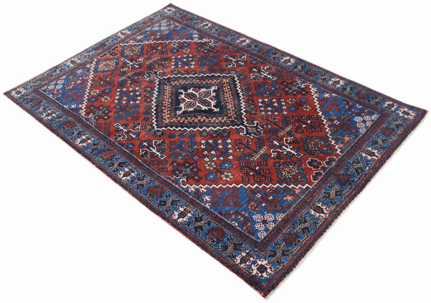 A vintage handwoven Persian Ghashghai rug featuring a geometric medallion on a red field.