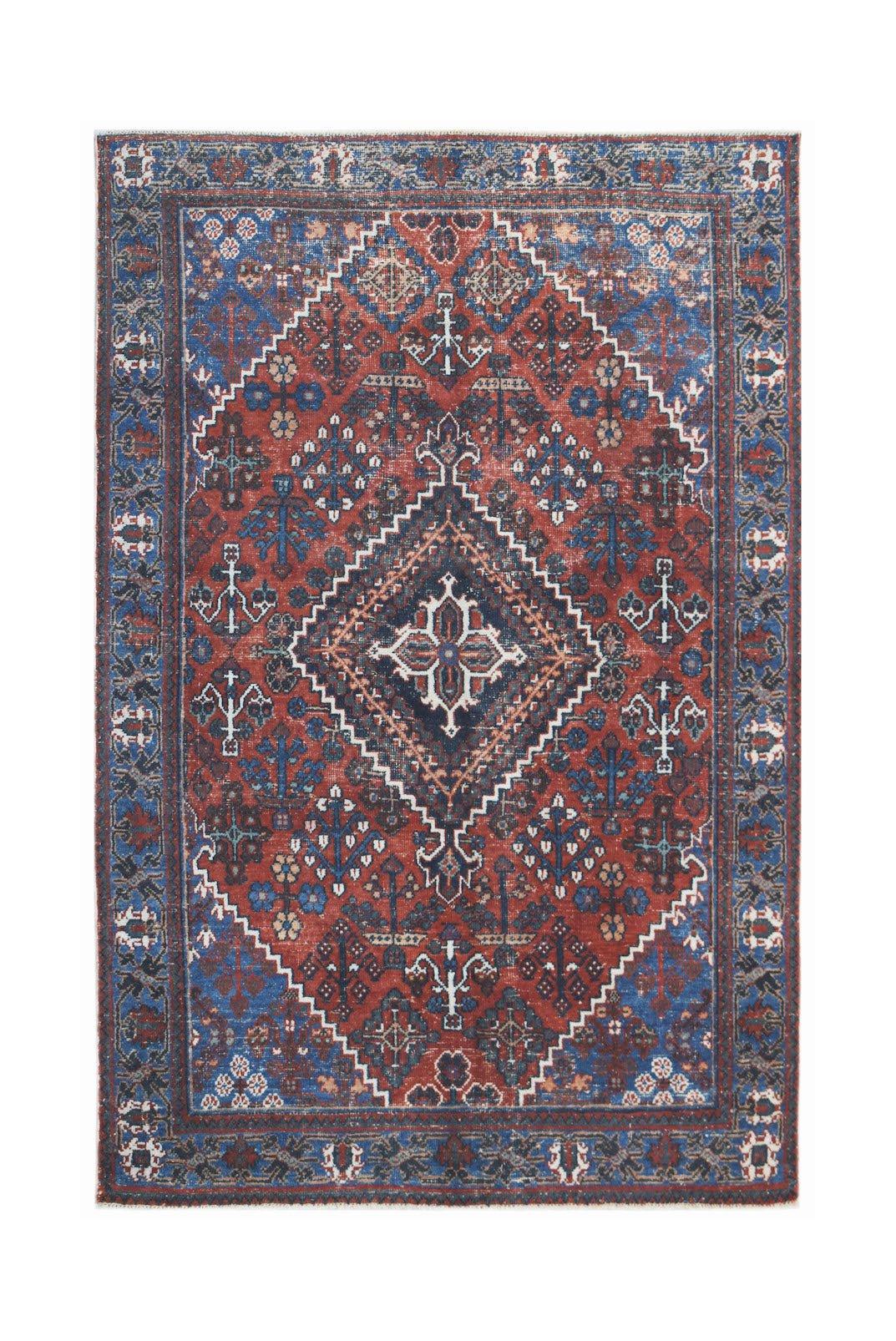 A vintage handwoven Persian Ghashghai rug featuring a central diamond motif in red and blue.