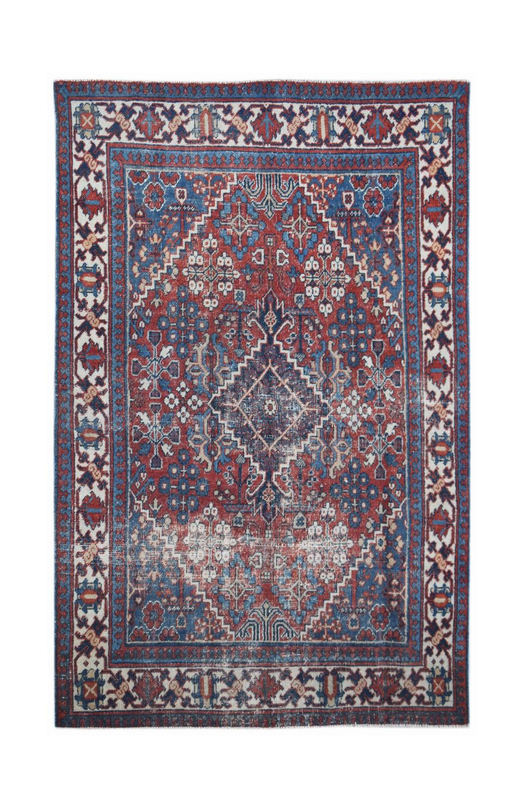 A vintage handwoven Persian Ghashghai rug featuring a geometric diamond pattern in red and blue.