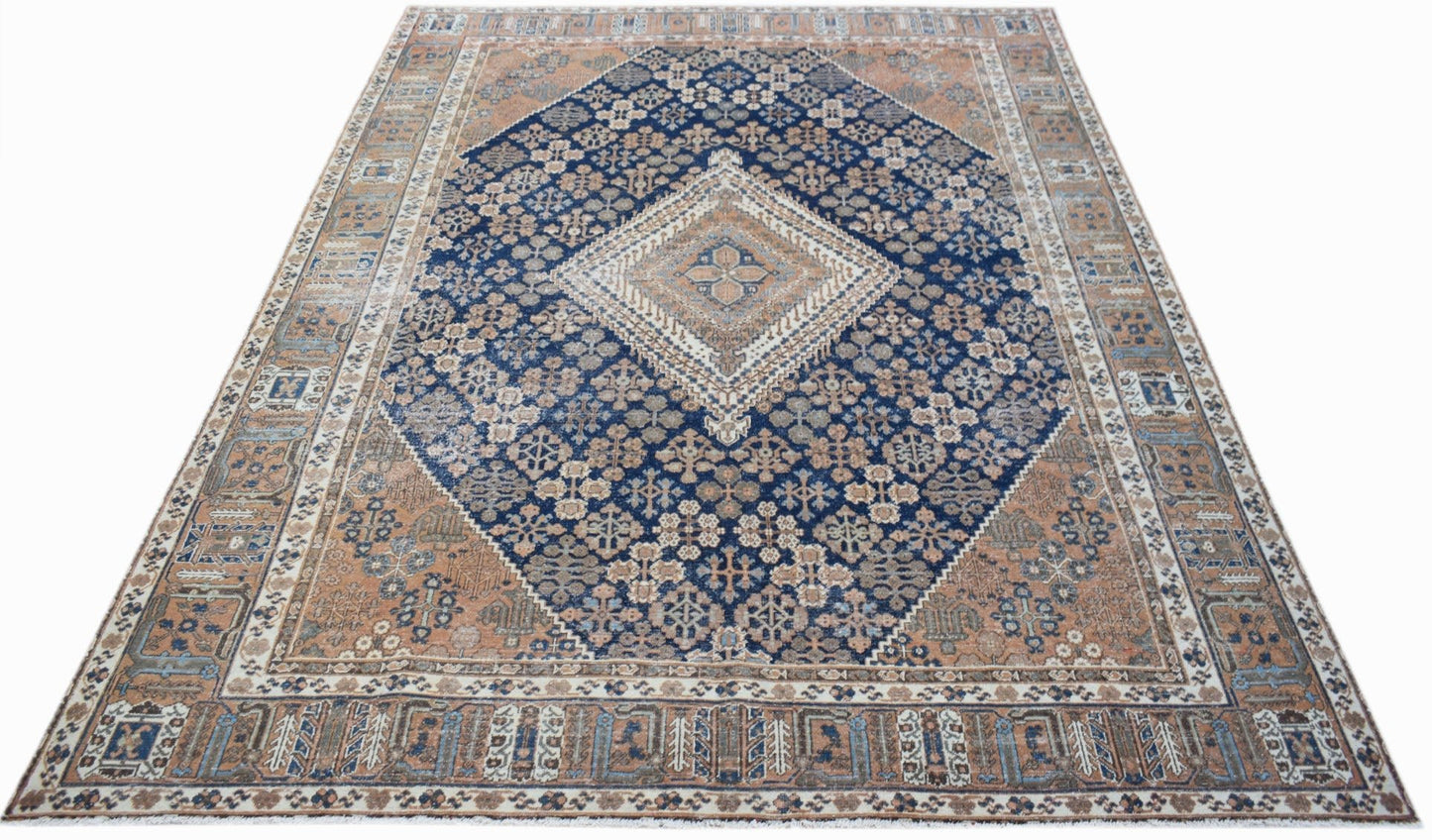 Vintage Persian Ghashghai rug featuring a central diamond medallion in blue and tan wool.