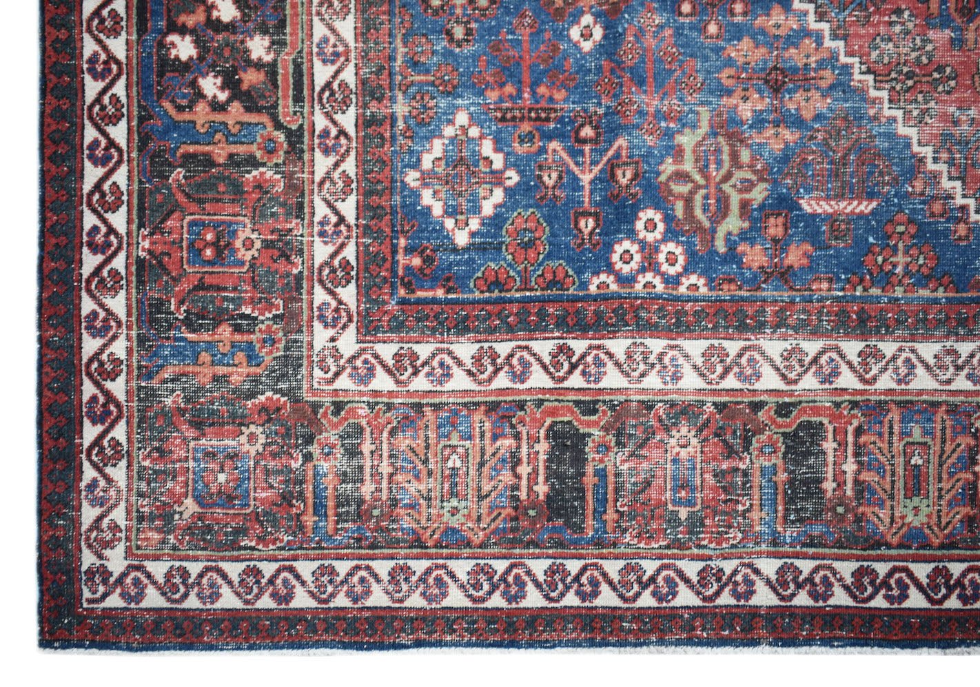 A vintage Persian Ghashghai rug featuring a blue field with intricate red and white geometric motifs.