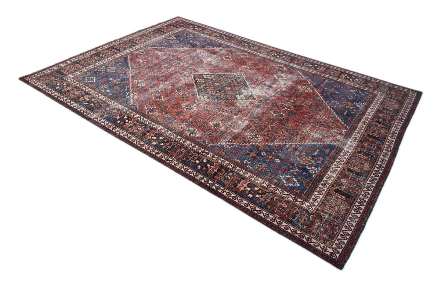 A vintage Persian Ghashghai rug featuring a distressed red and blue geometric pattern.