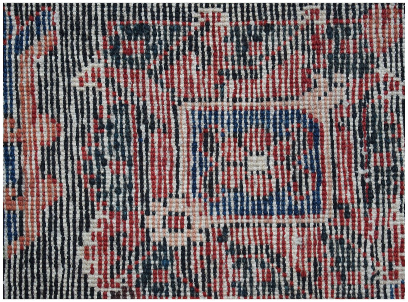 A close-up view of a vintage Persian Ghashghai rug featuring intricate geometric patterns in wool.