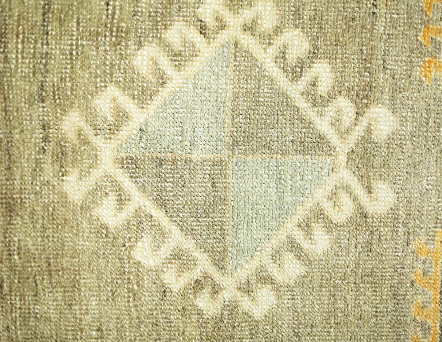 A close-up of a vintage Persian runner featuring a central diamond motif with geometric patterns.
