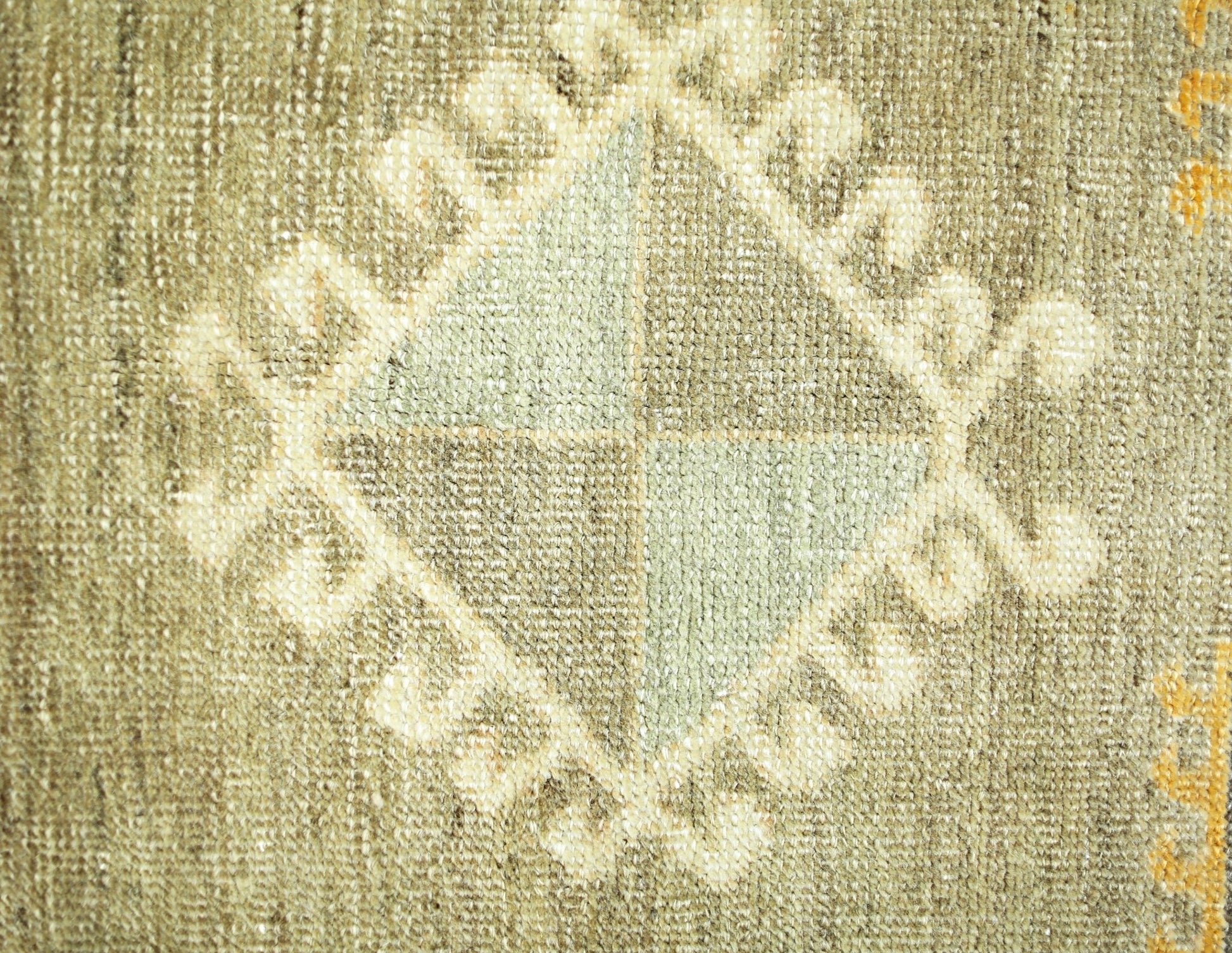 A close-up of a vintage Persian runner featuring a central diamond motif with geometric patterns.