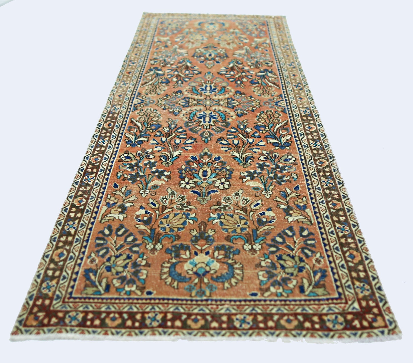A vintage Persian runner rug featuring intricate floral patterns in shades of orange and blue.