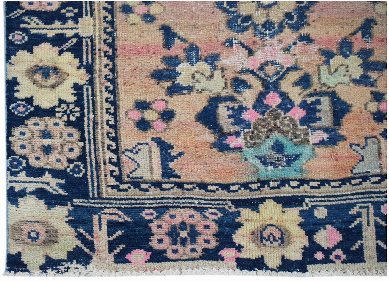 A vintage Persian runner featuring a floral pattern in blue, pink, and cream on an orange field.