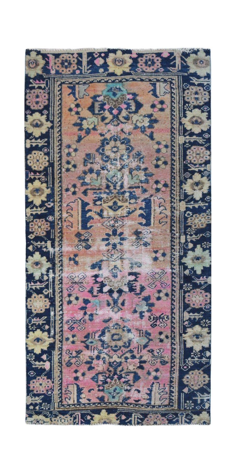 A vintage handwoven Persian runner featuring a floral pattern in pink, orange, and navy blue.