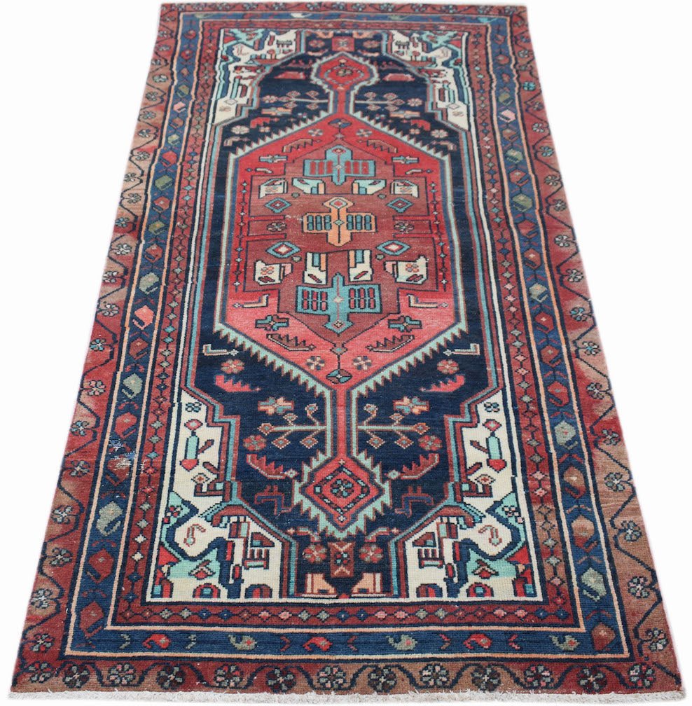 A handwoven vintage Persian runner featuring a geometric medallion pattern in red and navy blue.