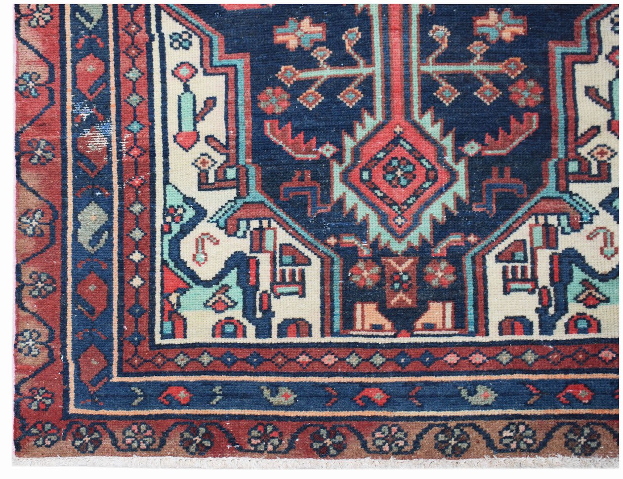 A handwoven vintage Persian runner featuring a geometric medallion pattern in blue, red, and cream.
