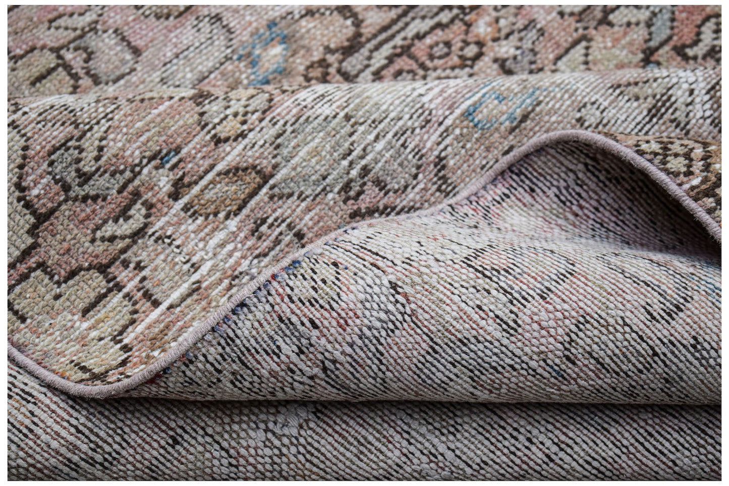 A folded vintage Persian Hamadan runner featuring a faded, intricate pattern in wool.