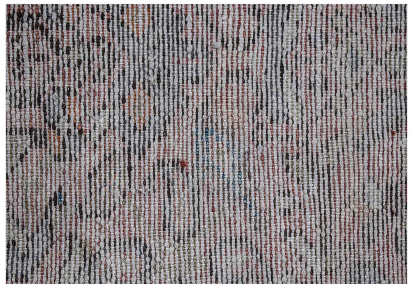 A close-up view of a vintage handwoven runner rug featuring a faded floral pattern in wool.