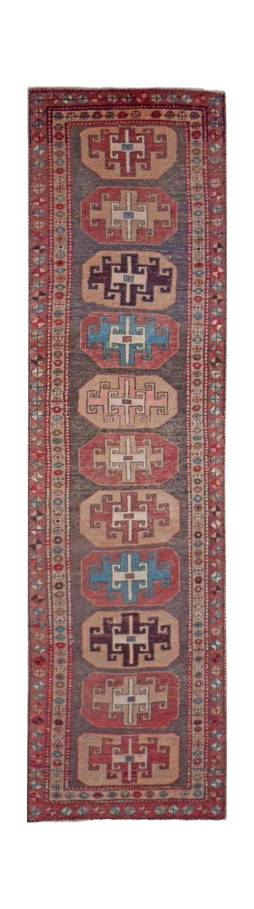 A handwoven vintage Persian runner featuring a series of geometric medallions on a dark field.