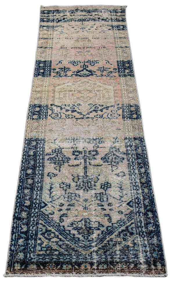 A vintage Persian Hamadan runner rug featuring a faded floral pattern in blue and peach tones.