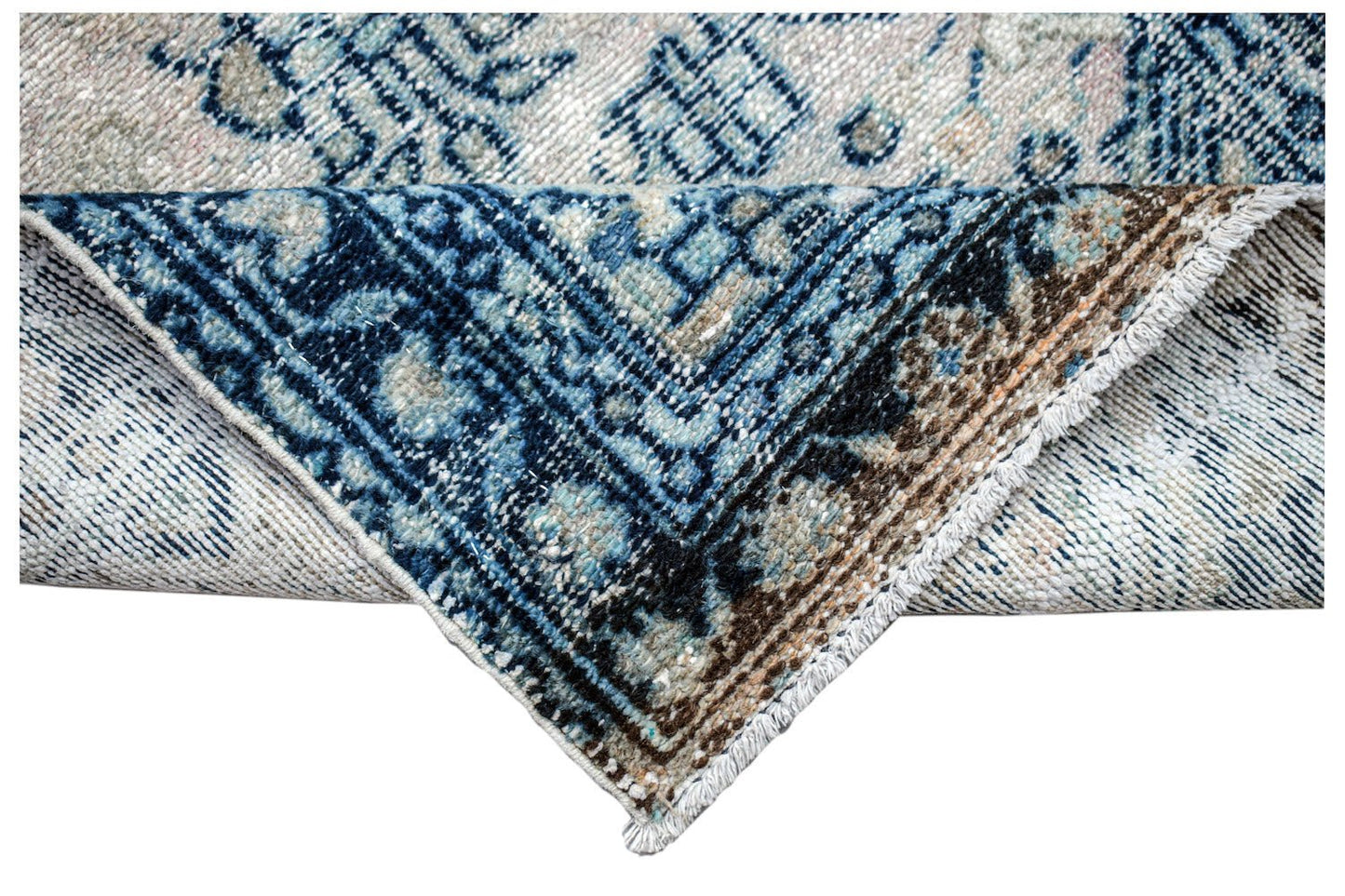 A corner of a vintage Persian Hamadan runner featuring intricate blue and cream floral patterns.