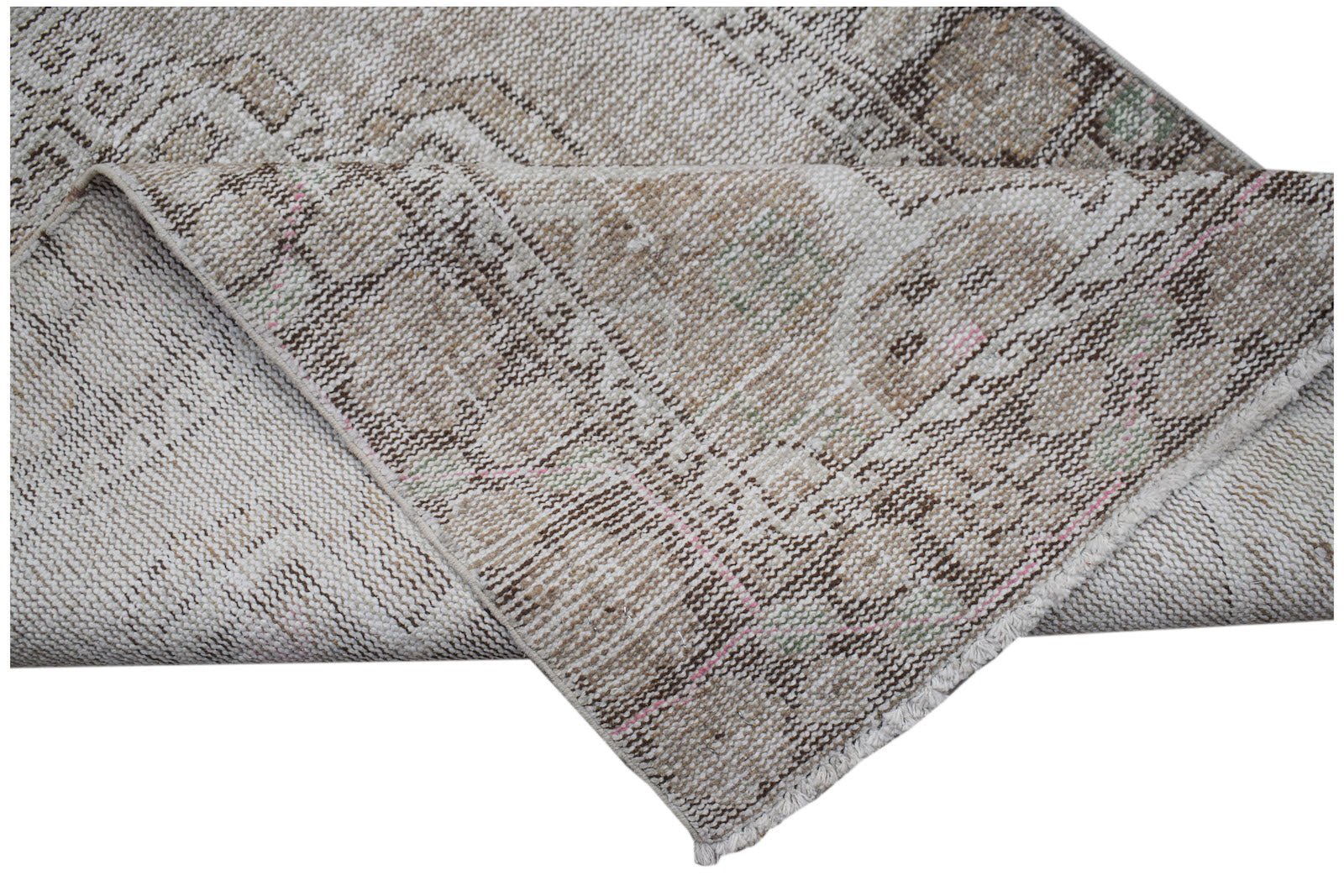 A vintage Persian runner with a faded geometric pattern in neutral brown and beige tones.