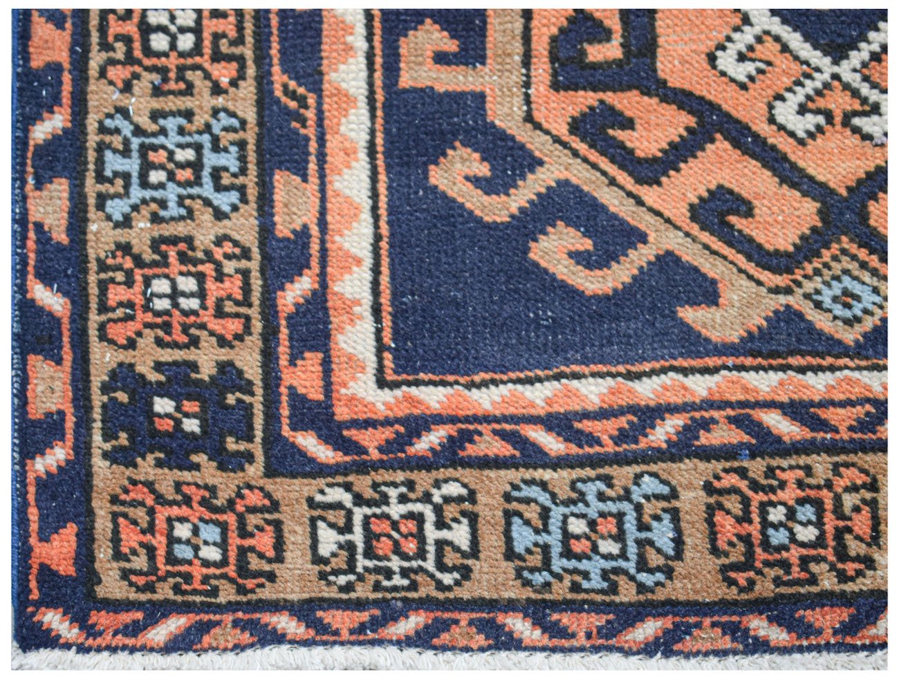 A handwoven vintage Persian runner featuring geometric patterns in blue, orange, and cream.