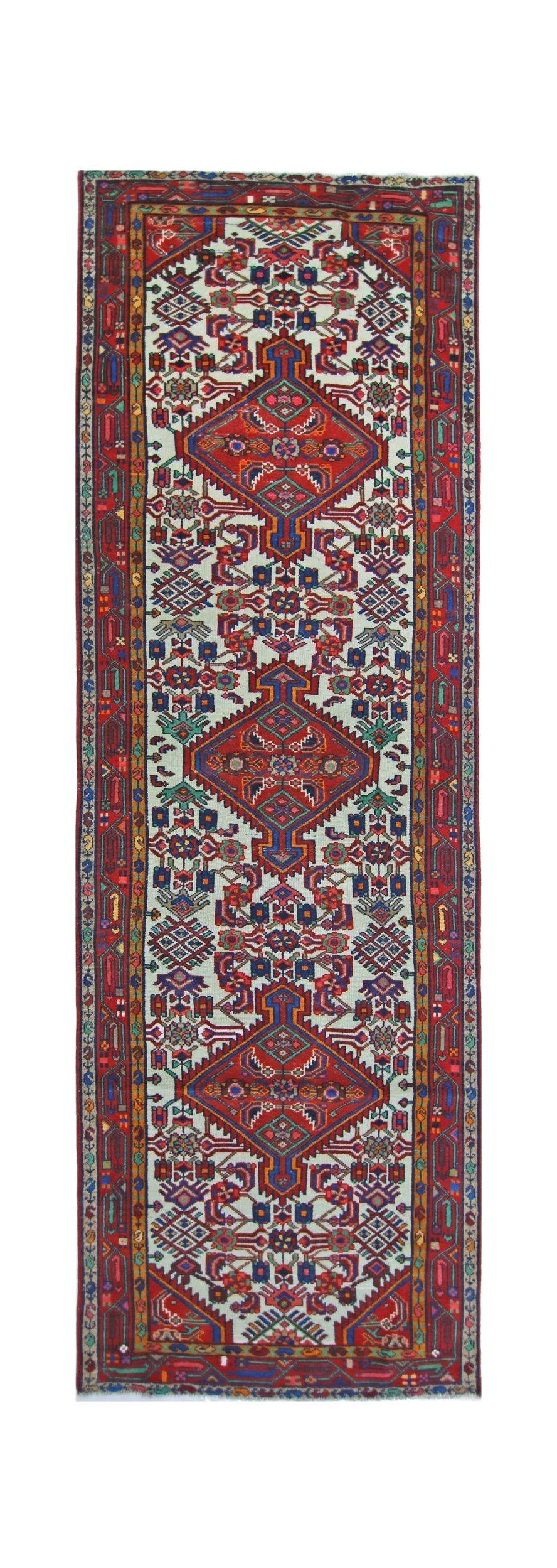 A vintage Persian Hamadan runner featuring a geometric pattern in red, blue, and cream tones.