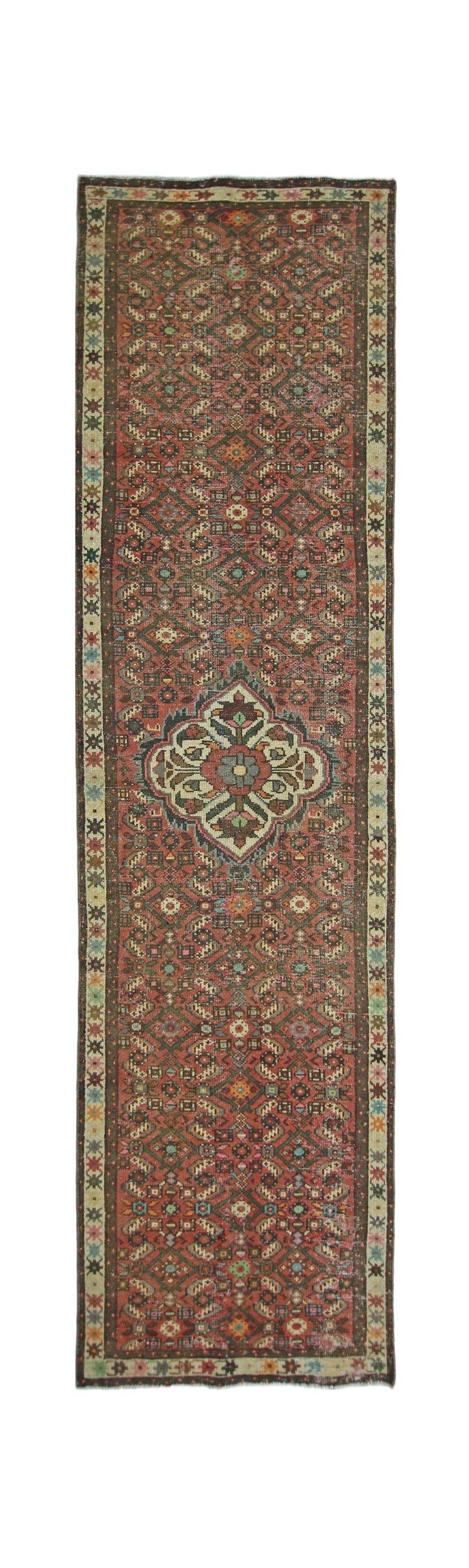 A vintage handmade Persian runner rug featuring a geometric pattern in red and multi-colored tones.