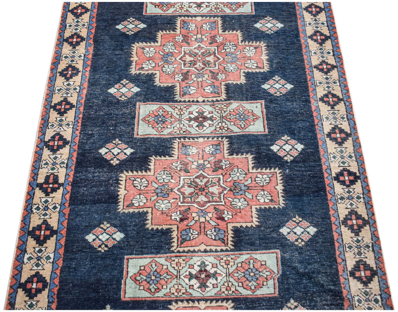 Vintage Persian Ardabil runner featuring geometric floral motifs in blue, pink, and cream.