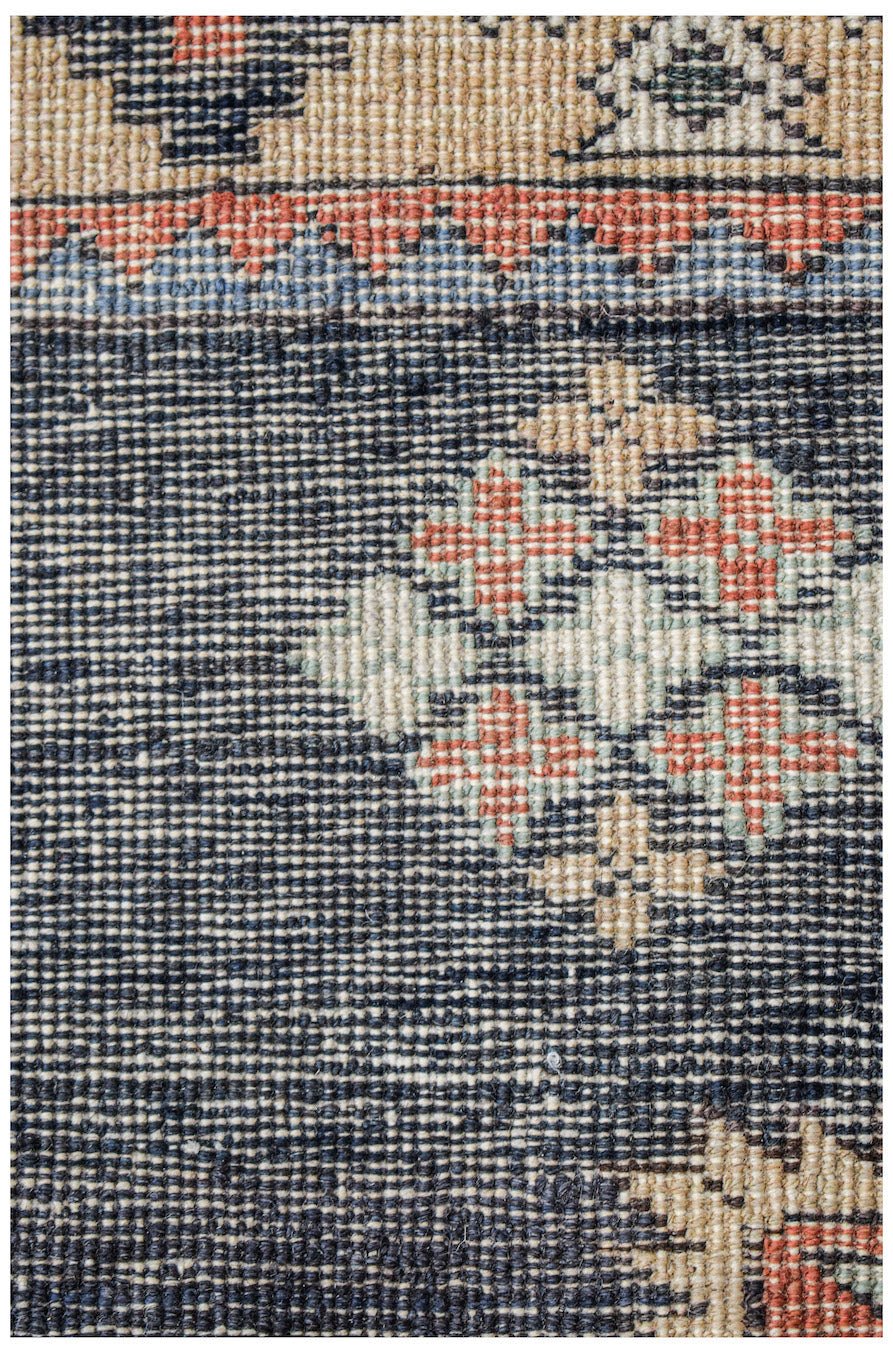 A close-up of a vintage Persian runner featuring a dark blue field with geometric floral motifs.