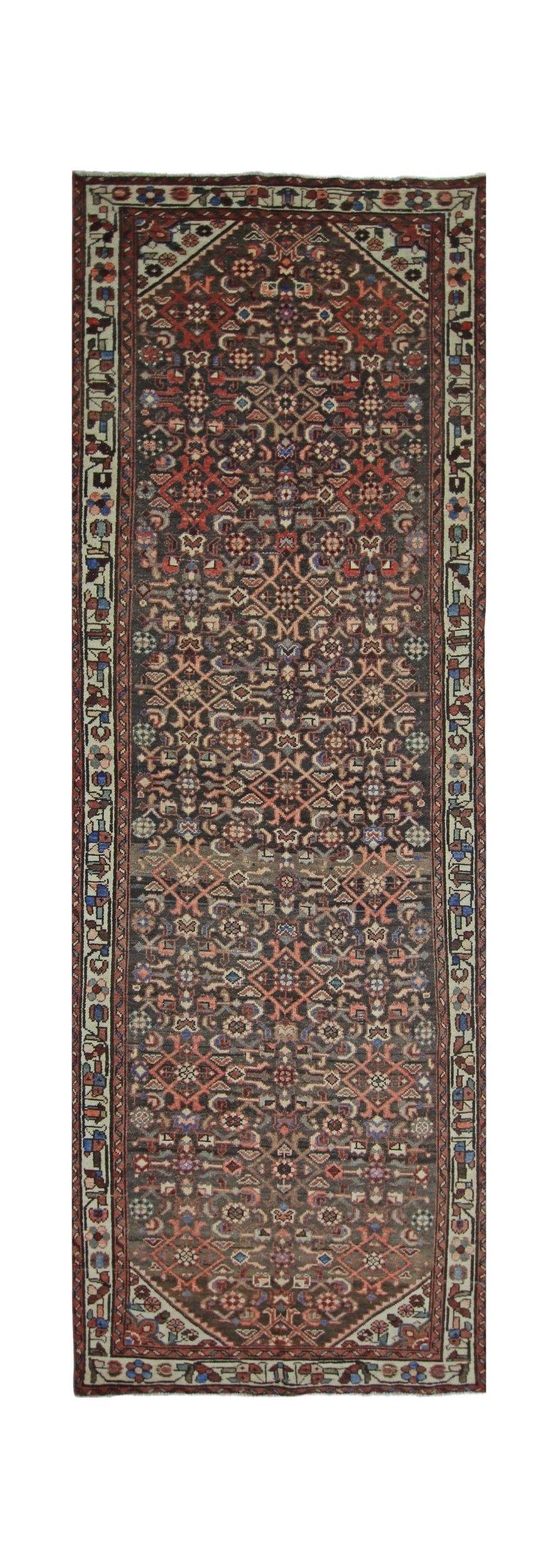 A vintage Persian Hamadan runner featuring a dark field with intricate geometric floral patterns.