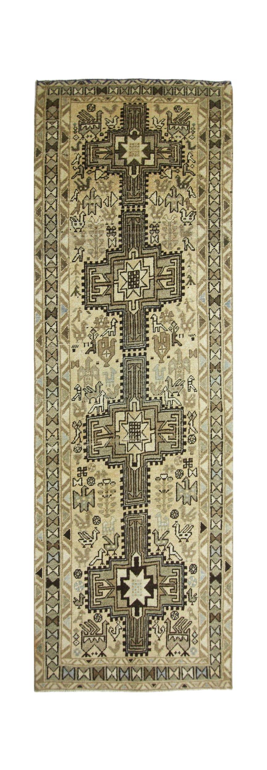 A vintage Persian Ardabil runner featuring a geometric central pole medallion and animal motifs.