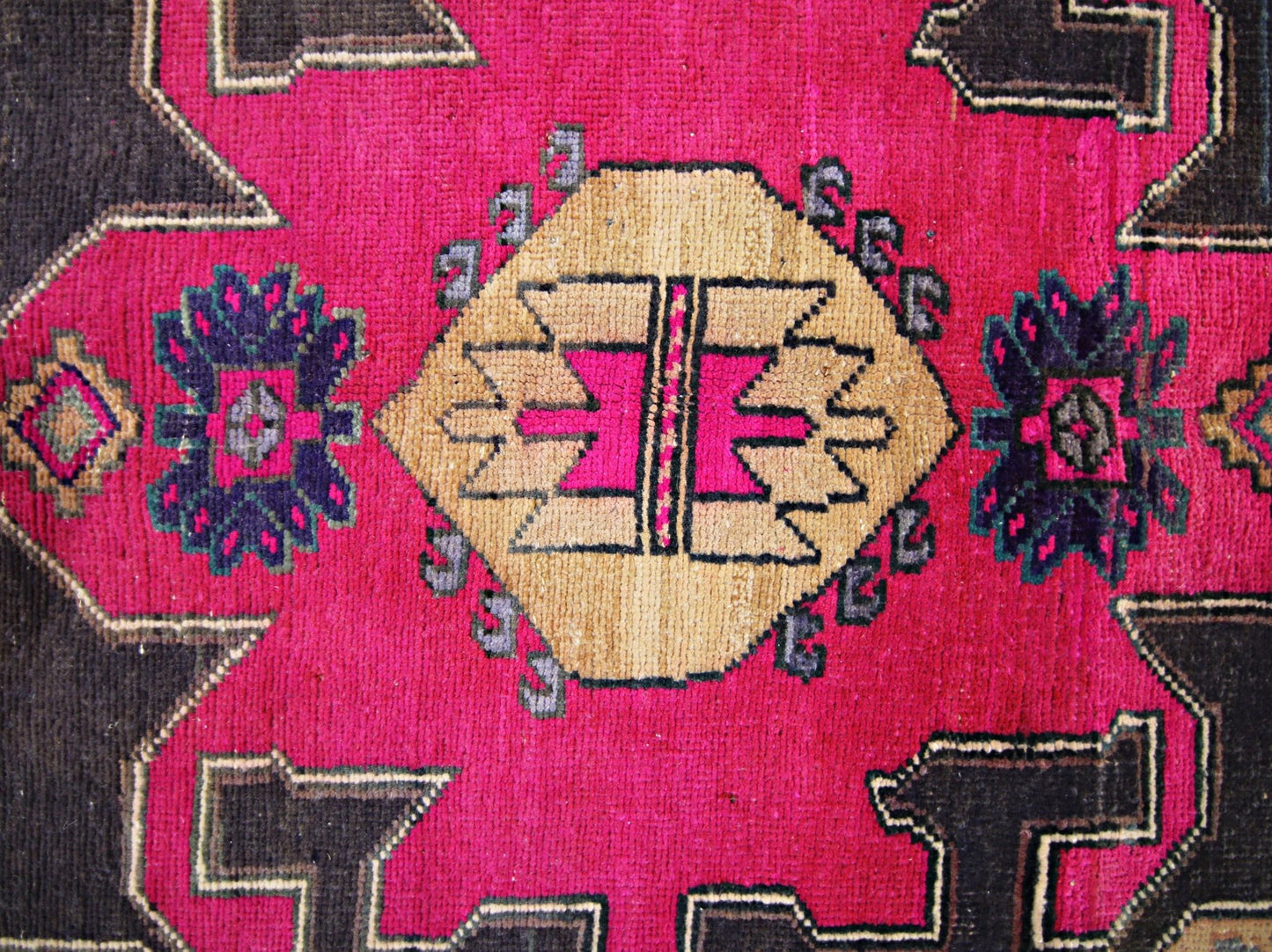 A vintage Persian Hamadan runner featuring a geometric medallion in tan and pink on a magenta field.
