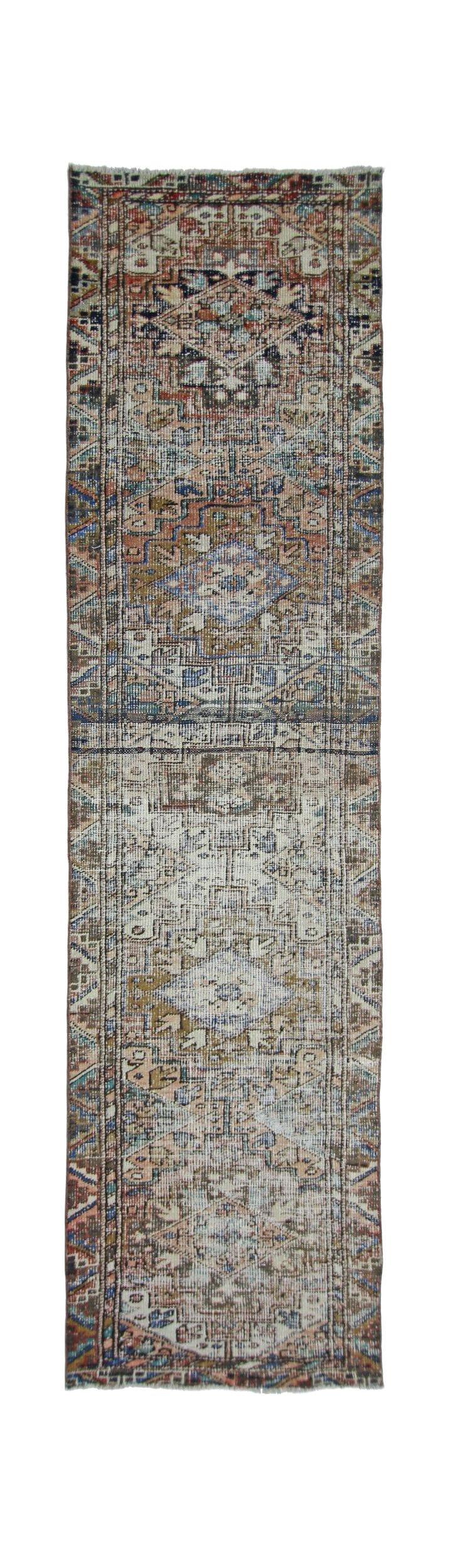 A vintage handmade Persian runner rug featuring a geometric pattern in muted earth tones.